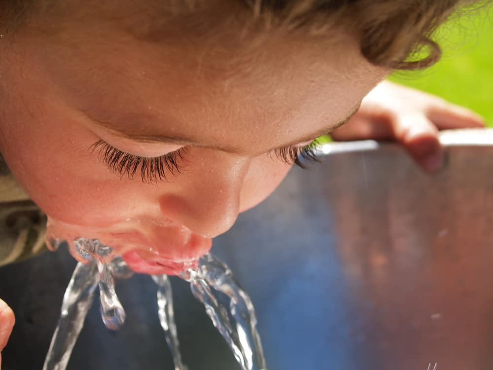 Child drinking from a water fountain