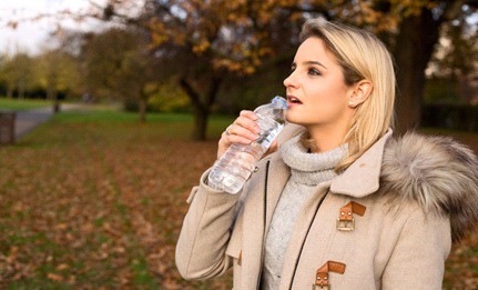 Women drinking water in a park in winter