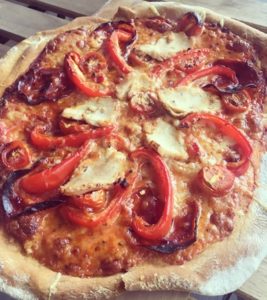Cooked pizza with tomatoes, peppers and chicken