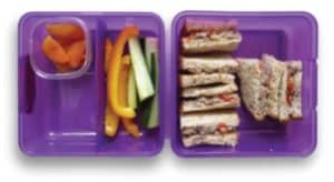Lunch box with sandwiches, cucumber and pepper slices and fruit pieces