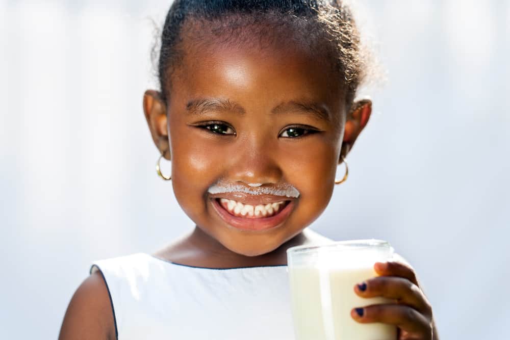 Child with a glass of milk and a mil moustache