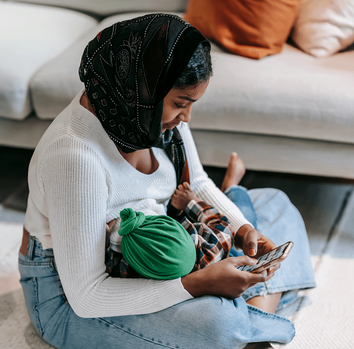 Muslim mother accessing breastfeeding support on her phone
