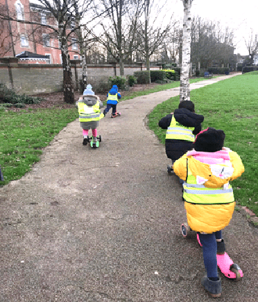 Children being active on scooters in a park