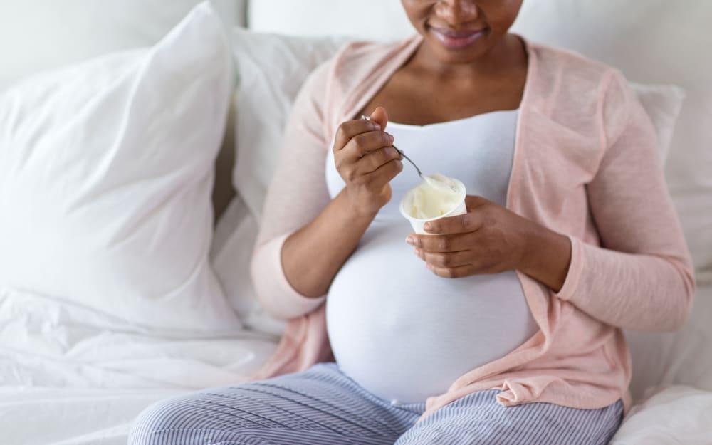 Pregnant woman eating yoghurt